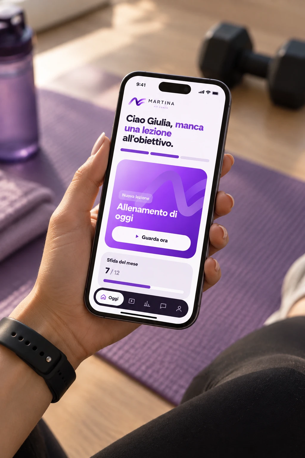 L'area di Martina Fitness aperta su un telefono, sul tappetino accanto ai manubri